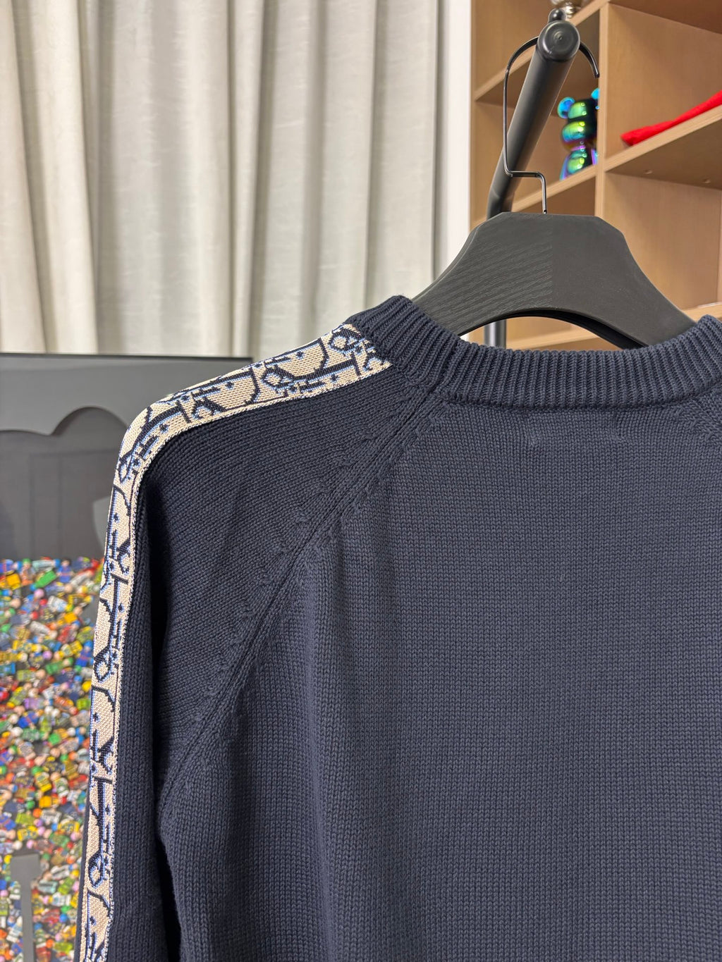 Dior long-sleeve knit sweater close-up, dark navy with patterned shoulder stripe