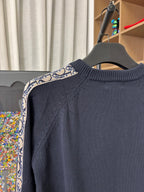 Dior long-sleeve knit sweater close-up, dark navy with patterned shoulder stripe