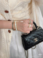 Stack of rhinestone and gold-tone cuff bracelets worn on wrist