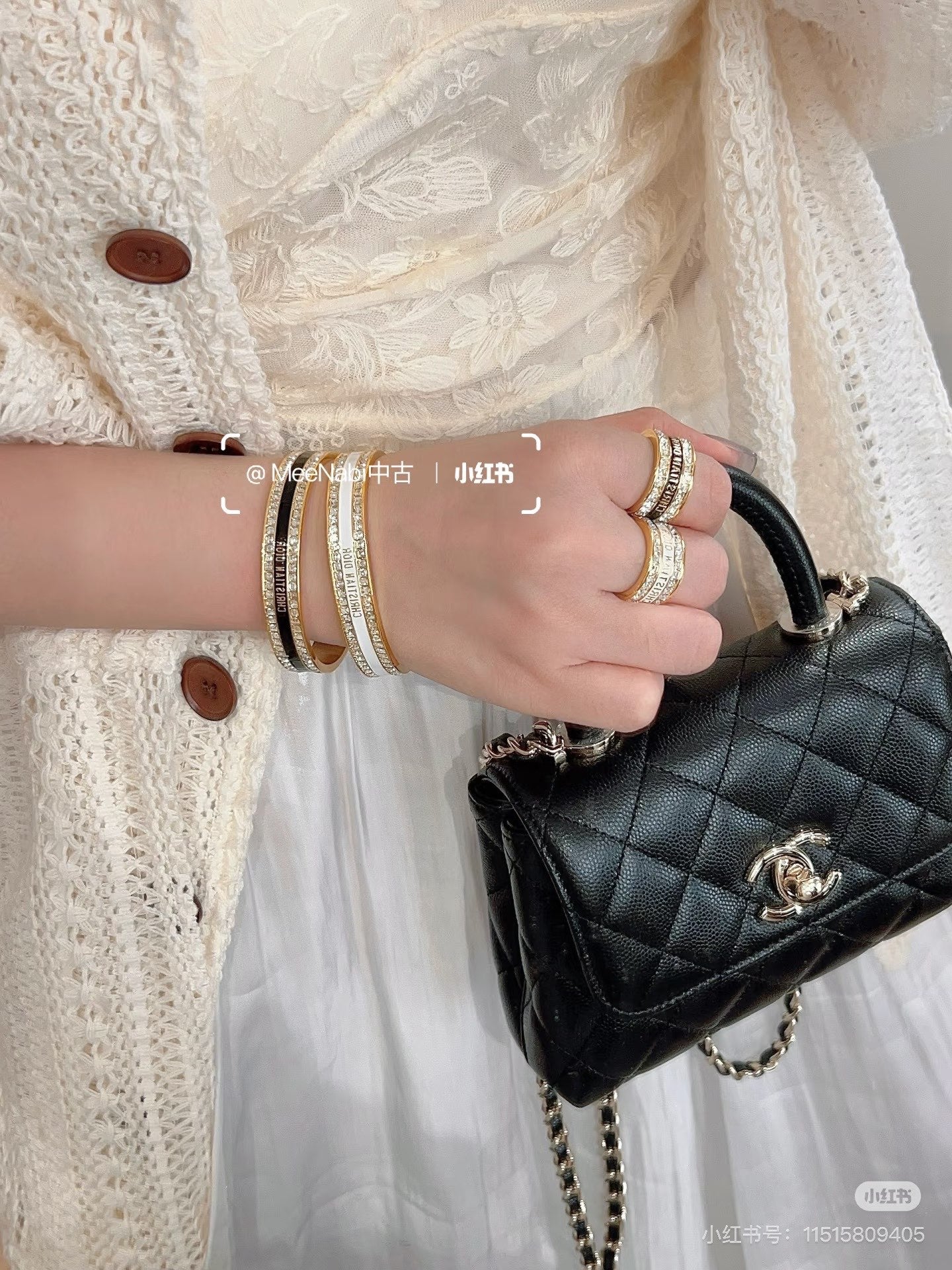 Stack of rhinestone and gold-tone cuff bracelets worn on wrist