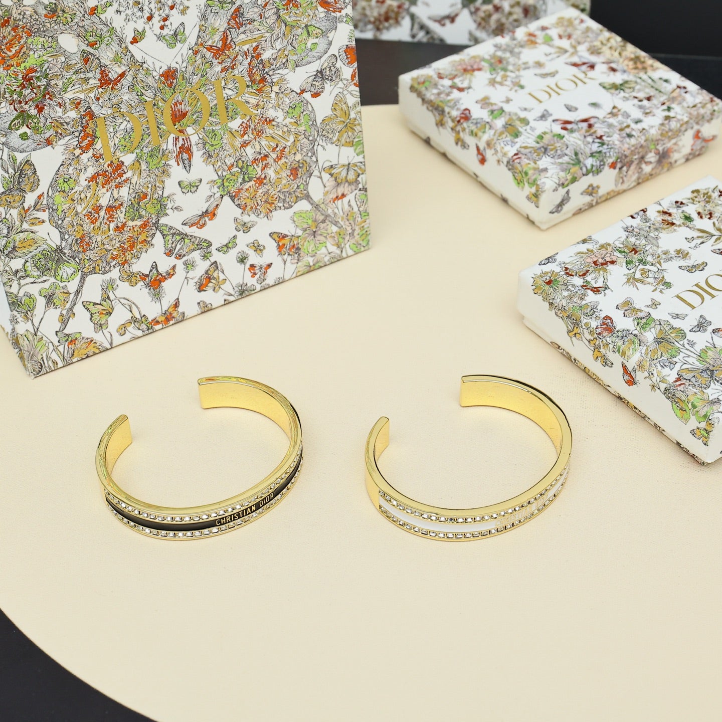 Pair of gold-tone cuff bracelets with rhinestone pavé and black enamel center stripe