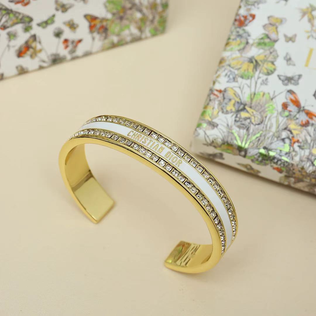 Gold-tone Christian Dior cuff bracelet with black enamel center and clear crystal pavé band