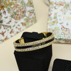 Gold-tone Christian Dior cuff bracelet with black enamel center and rhinestone pavé trim