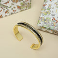 Gold-tone Christian Dior cuff bracelet with black enamel center and crystal pavé trim