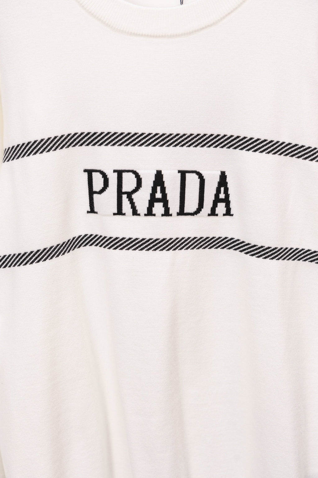 White sweater with centered PRADA logo over black striped band