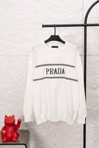 White long-sleeve crewneck sweater with PRADA logo and black striped band across chest