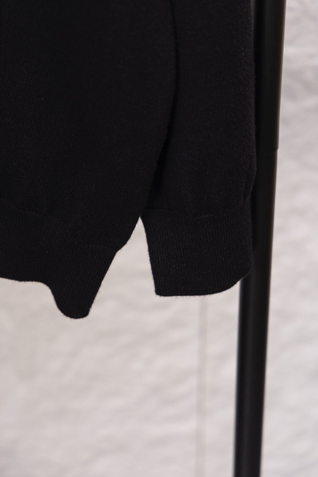 Black sweater lower hem with ribbed knit cuff and side seam detail