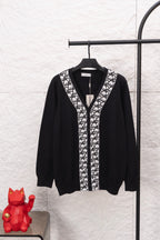 Black long-sleeve V-neck sweater with white patterned front placket and trim