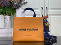 Louis Vuitton handbag in orange with blue leather handles and front logo.