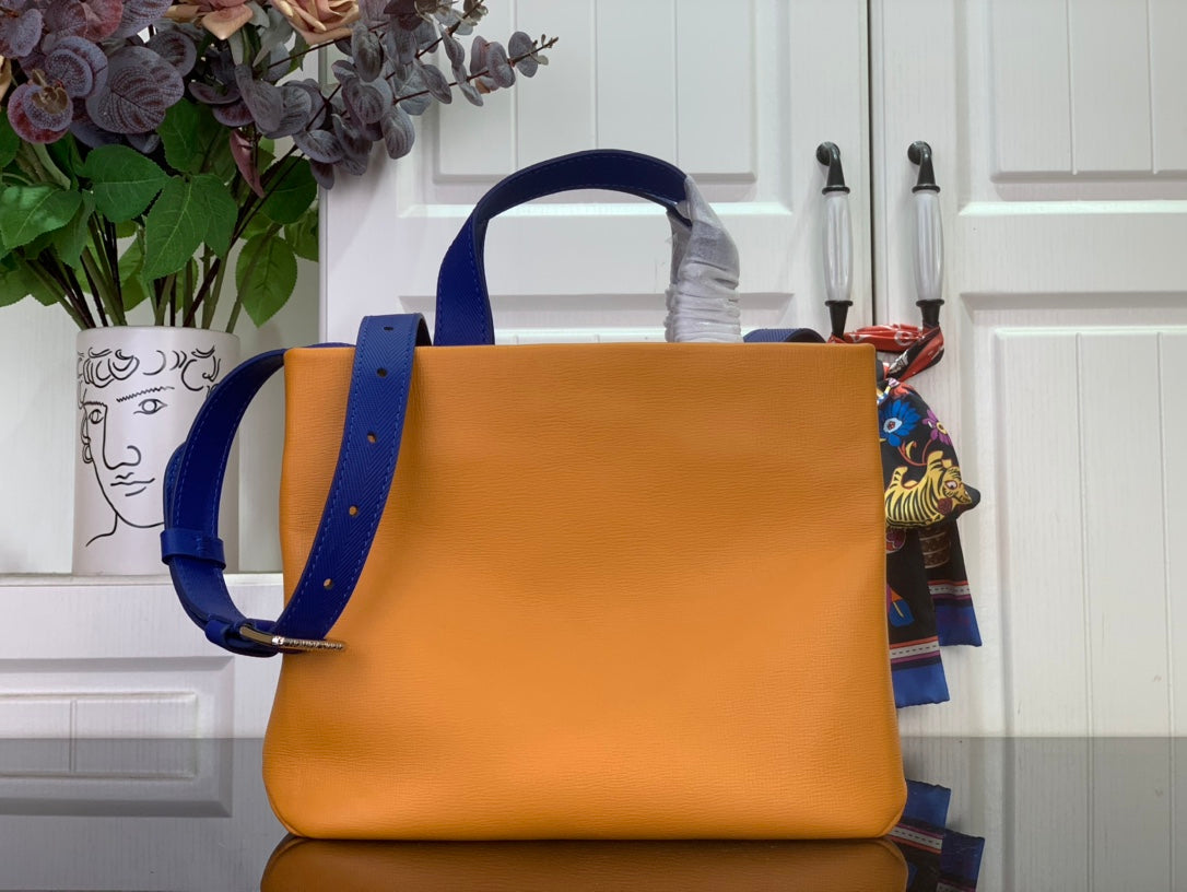 Handbag in orange with blue shoulder strap and top handle, side view.