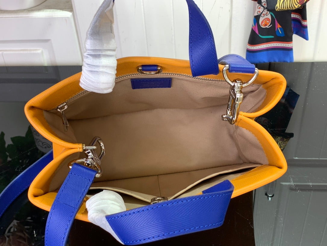 Orange handbag interior with beige lining, blue straps, and silver clasps.