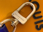 Metal clasp with Louis Vuitton engraving on orange leather bag.