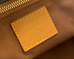 Leather interior tag with Louis Vuitton text and gold stitching.
