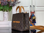 Tote bag in brown monogram canvas with tan top handles and shoulder strap.