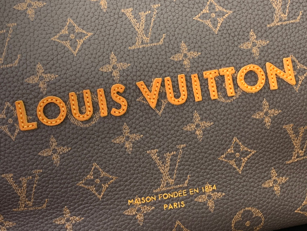 Brown monogram canvas with gold Louis Vuitton lettering and small text.