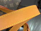 Tan leather strap detail with yellow stitching and textured finish.