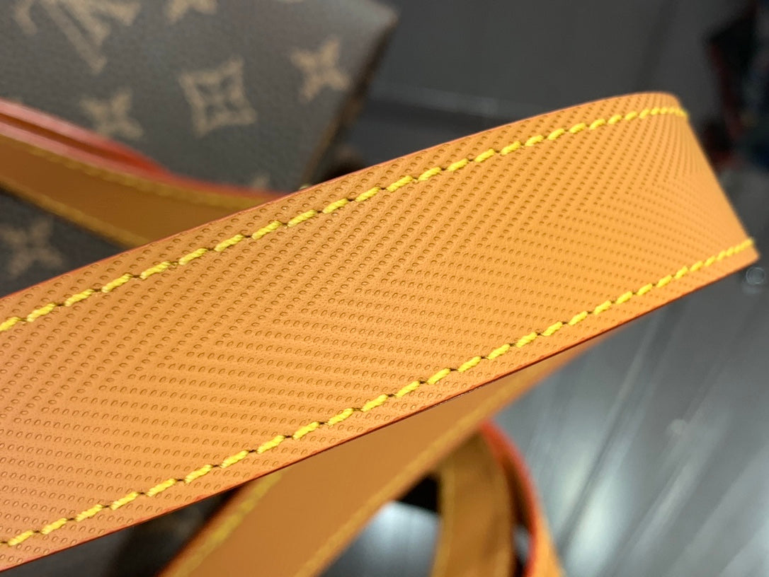 Tan leather strap detail with yellow stitching and textured finish.