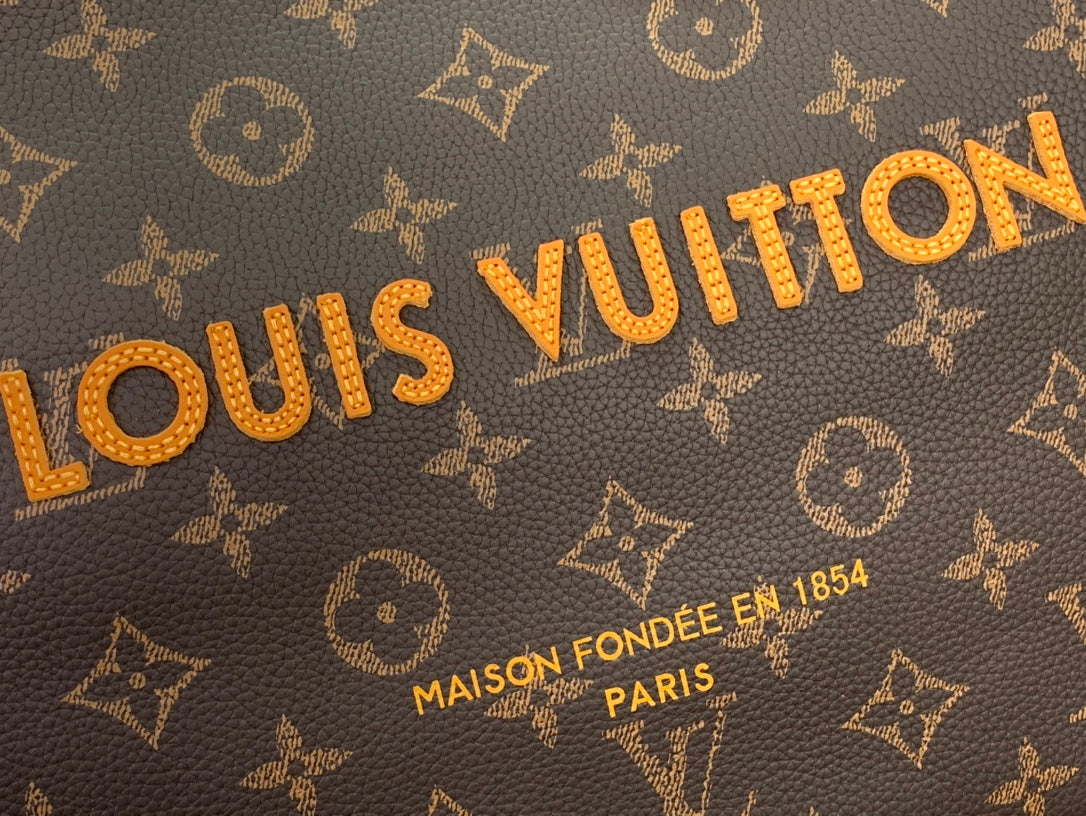 Louis Vuitton monogram canvas close-up with gold lettering and accents