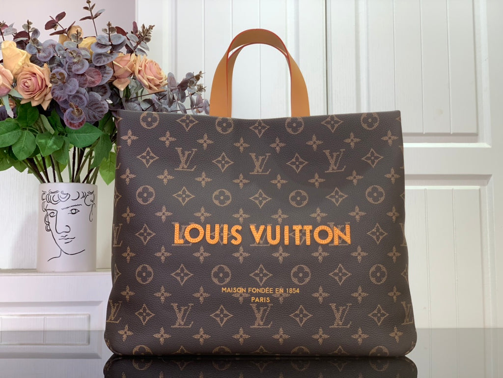Louis Vuitton monogram tote bag with tan handles and front logo print