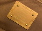 Louis Vuitton interior leather label with embossed text and gold rivets