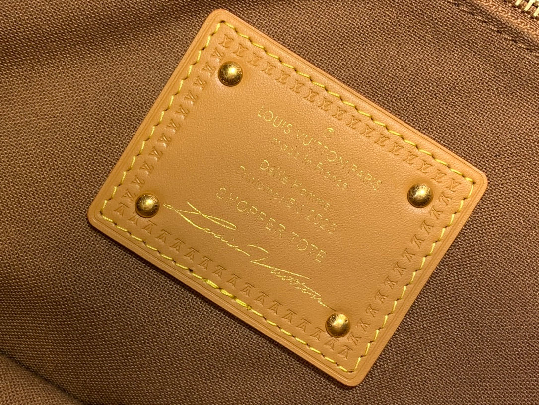 Louis Vuitton interior leather label with embossed text and gold rivets