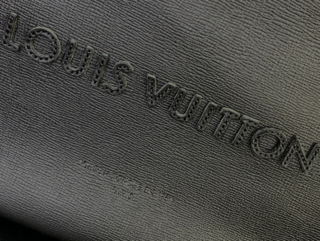 Louis Vuitton embossed logo on textured leather bag, dark finish