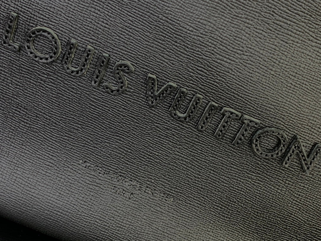 Louis Vuitton embossed logo on textured leather bag, dark finish