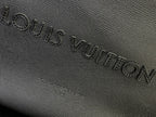 Louis Vuitton embossed leather panel on dark bag surface
