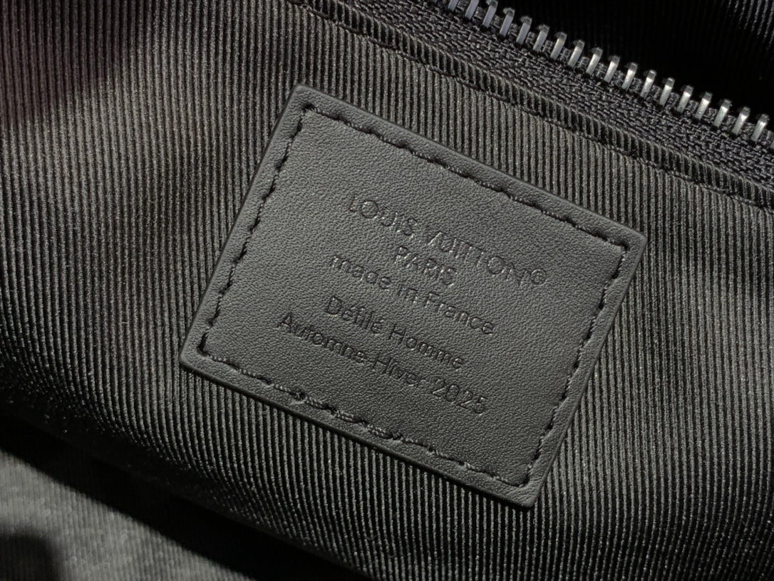 Louis Vuitton inner label patch with embossed text on dark fabric