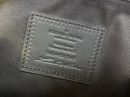 Leather brand tag on tote bag showing Louis Vuitton Paris and production details
