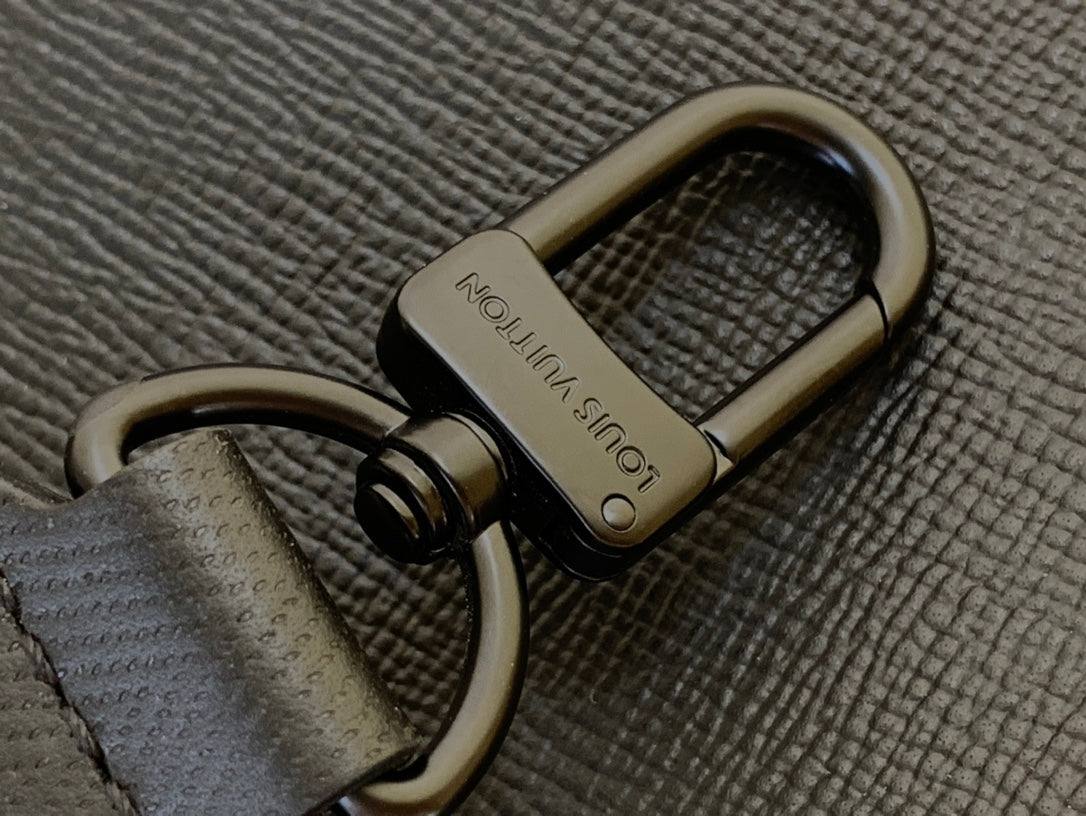 Close-up of snap hook on textured strap with embossed logo