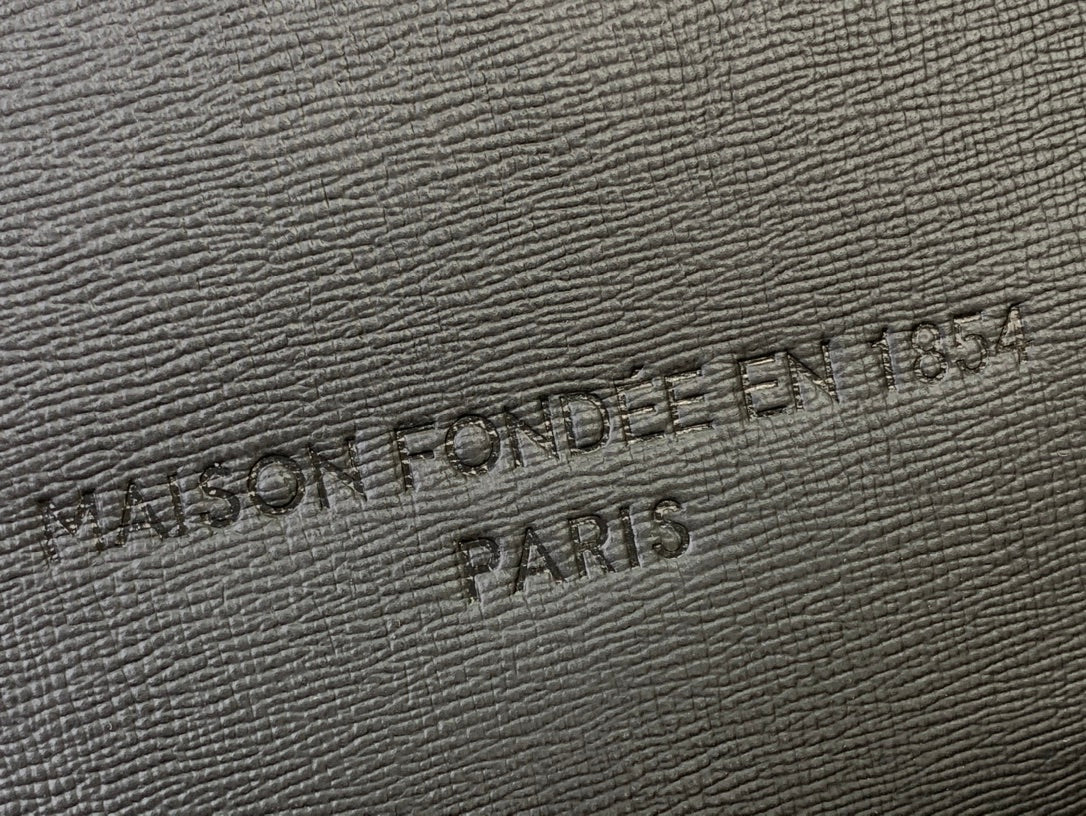 Embossed Louis Vuitton logo on textured leather patch