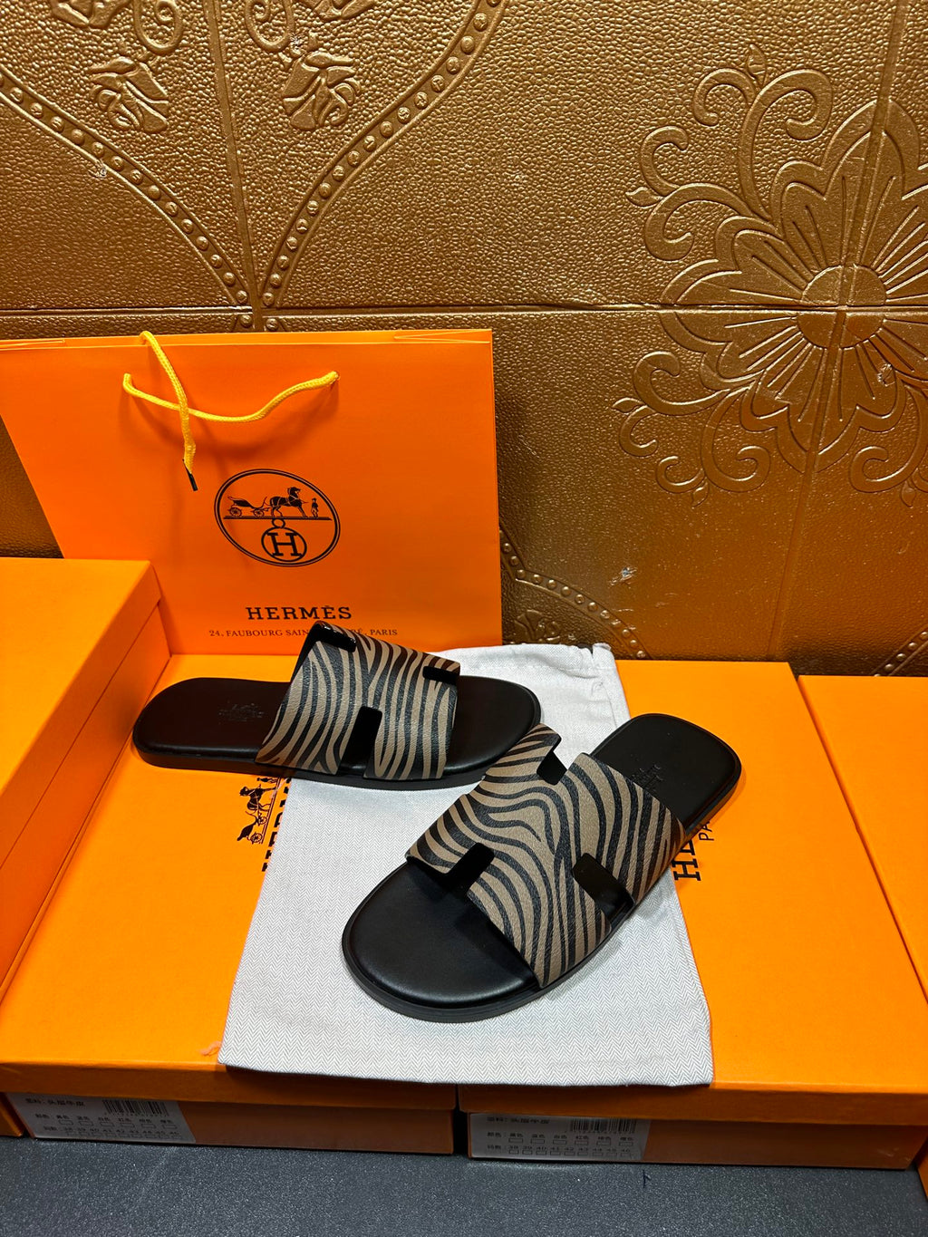 Black slide sandals with zebra-striped straps, displayed with one slightly turned.