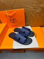 Blue patterned slide sandals with black strap tabs