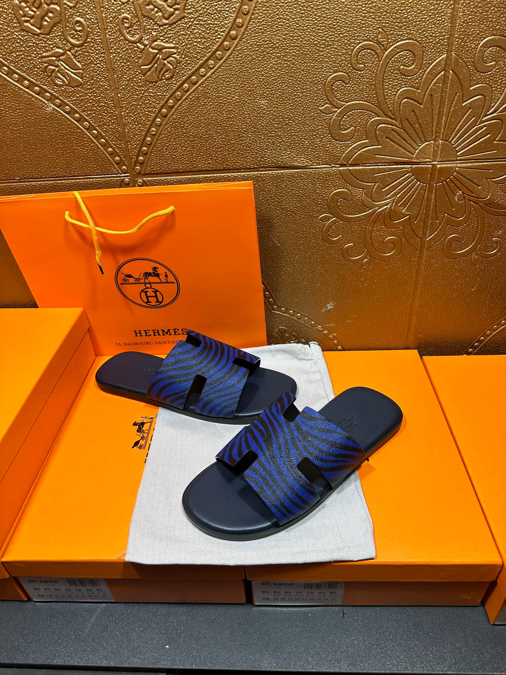 Blue patterned slide sandals with black strap accents