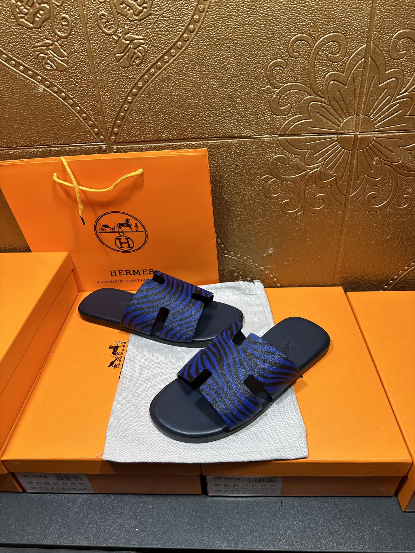 Blue patterned slide sandals with black strap accents