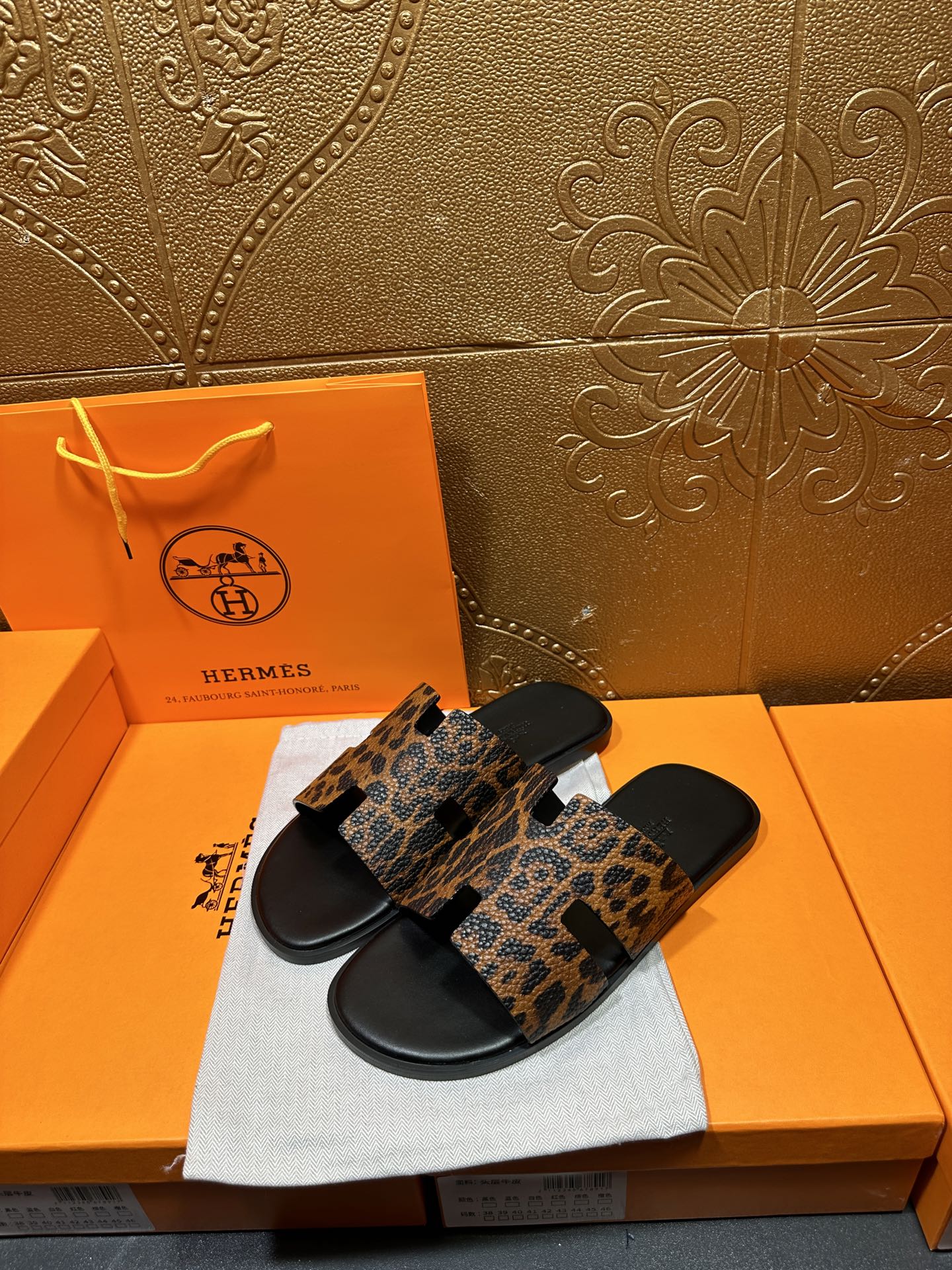 Pair of leopard-print slide sandals with black footbed and straps, shown at an angle.
