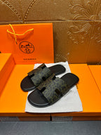 Hermes luxury slide sandals, front cross-strap detail on dark patterned upper