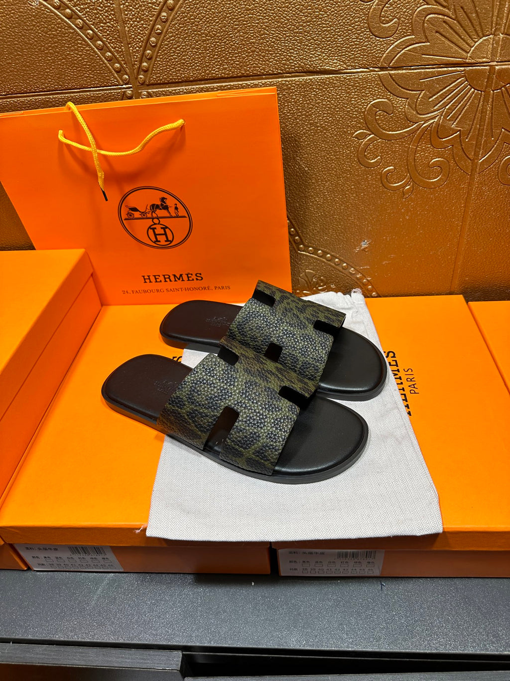 Hermes luxury slide sandals, dark patterned straps over black molded sole