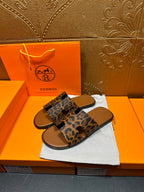 Hermes leopard-print slide sandals with wide strap across the foot