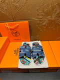 Blue denim slide sandals with colorful patterned footbed and adjustable strap