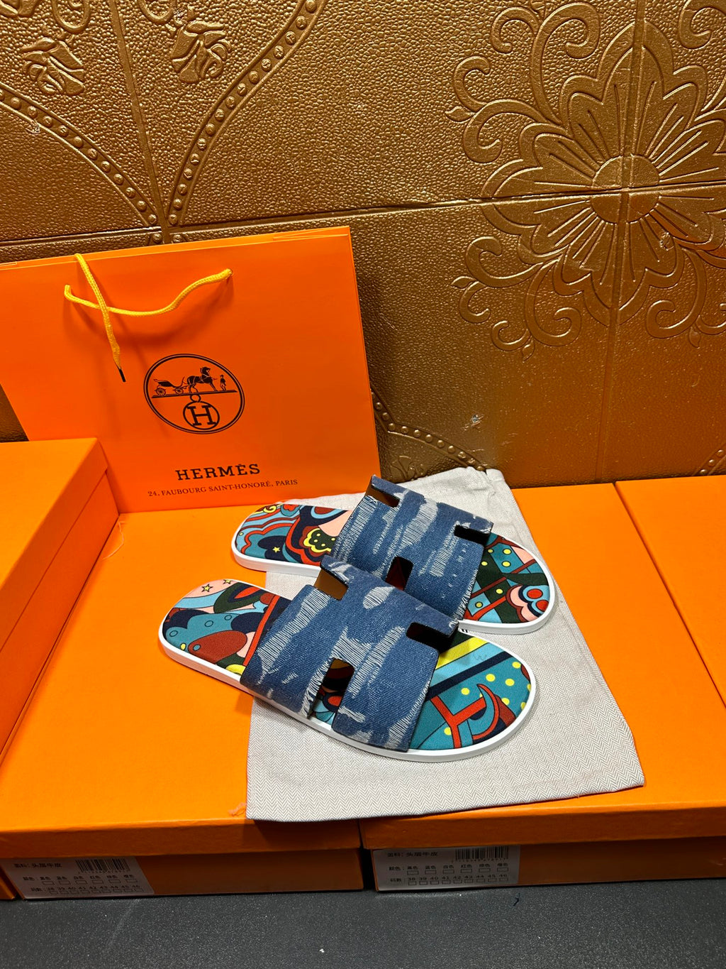 Blue denim slide sandals with adjustable strap and colorful patterned top view