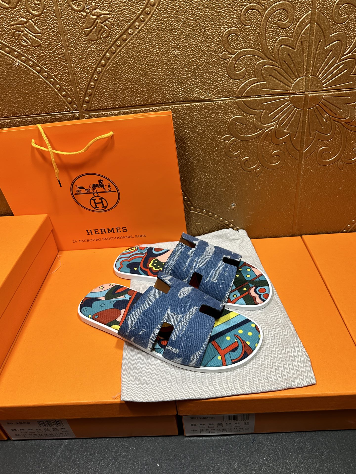 Blue denim slide sandals with adjustable strap and colorful patterned top view