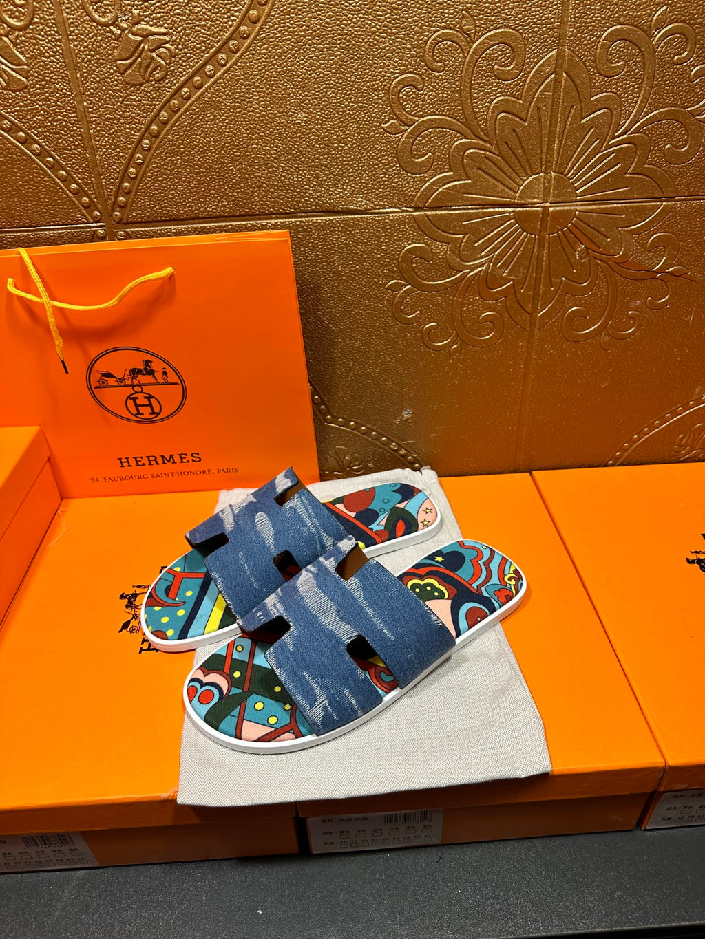Blue slide sandal pair on cloth bag, colorful graphic straps over white sole