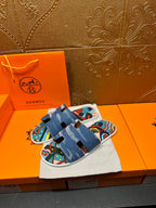Blue slide sandal pair on cloth bag, colorful graphic straps over white sole