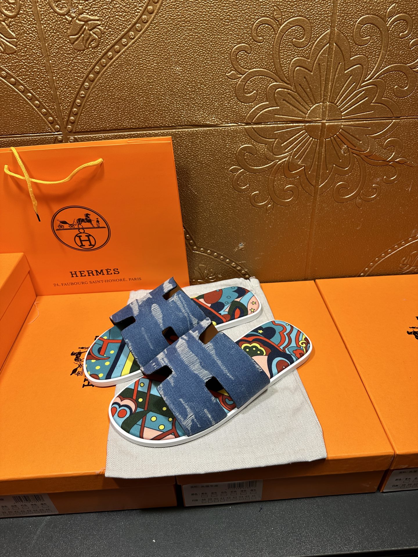 Blue slide sandal pair on cloth bag, colorful graphic straps over white sole