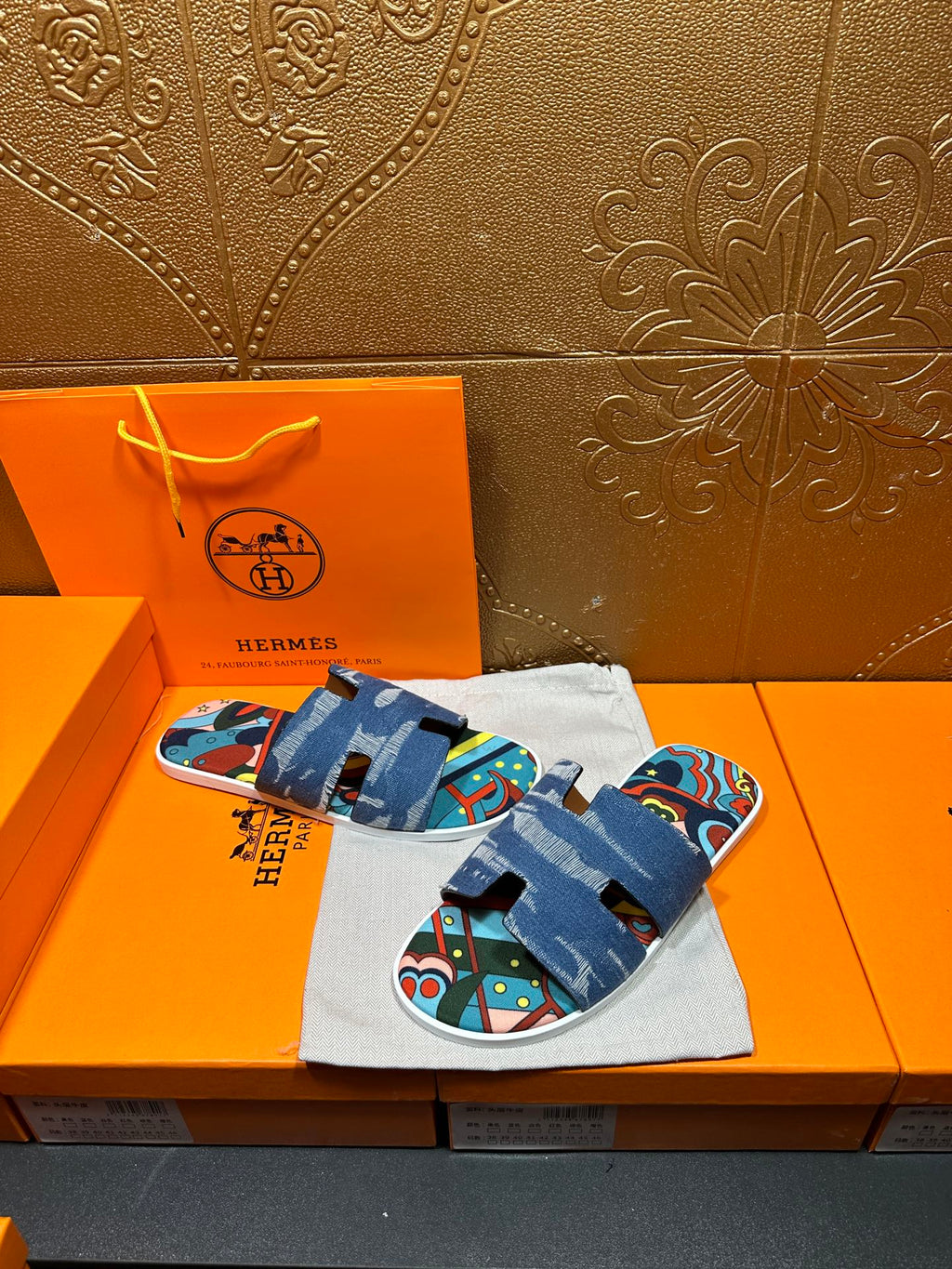 Blue slide sandals with colorful patterned footbed and thick denim strap
