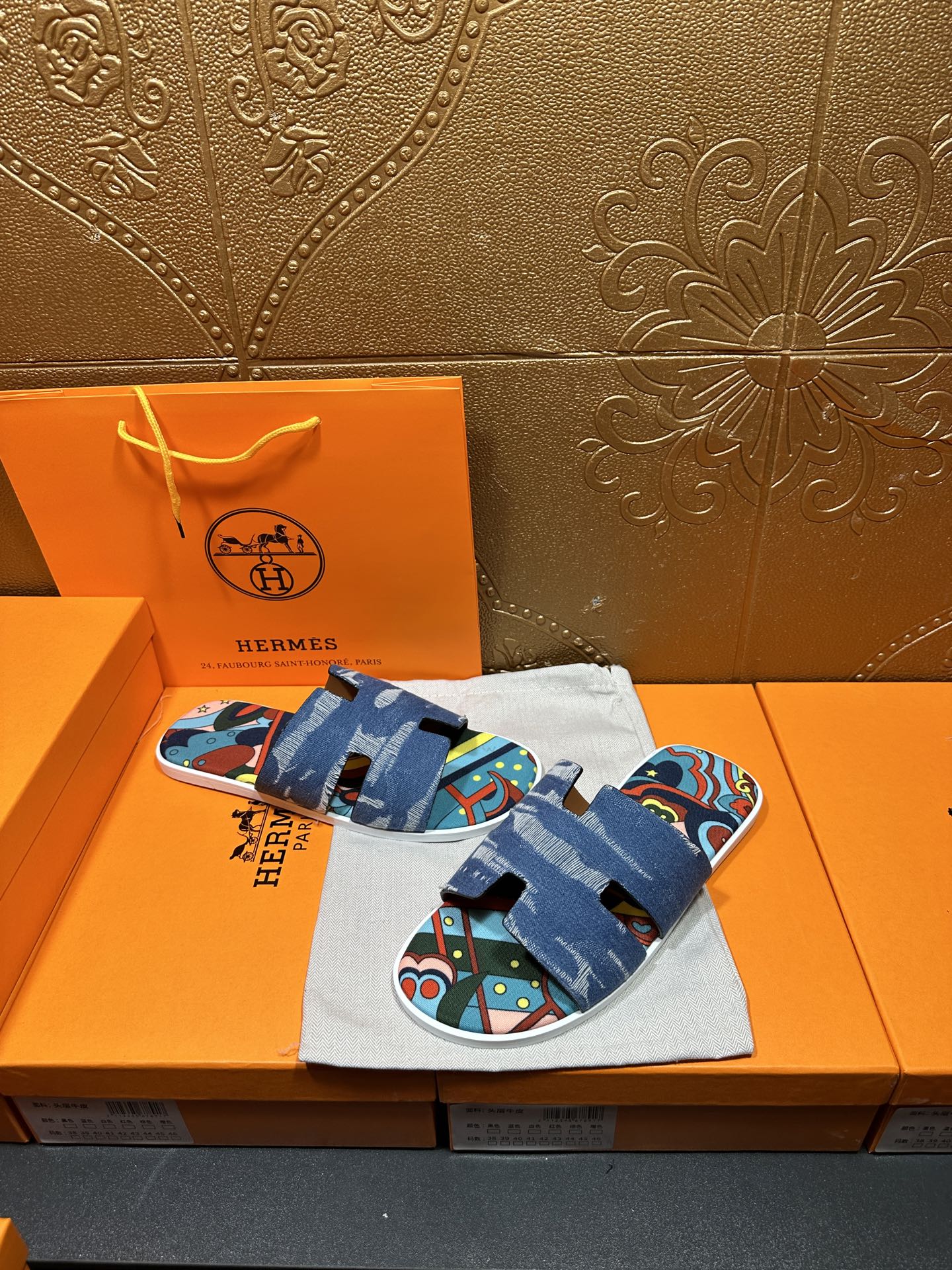 Blue slide sandals with colorful patterned footbed and thick denim strap