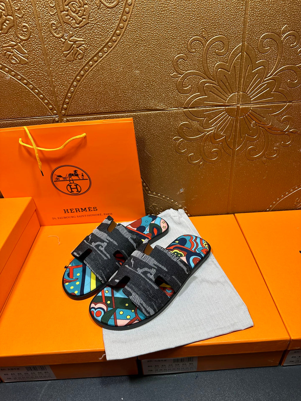 Hermes slide sandals with black textured straps and multicolor abstract panel