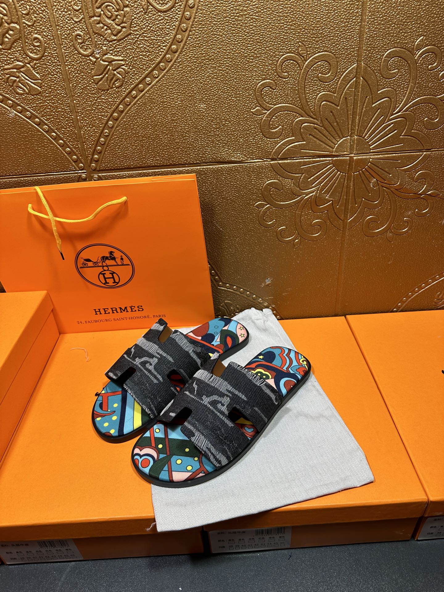 Hermes slide sandals with black textured straps and multicolor abstract panel